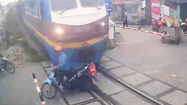 Xe máy liều lĩnh băng qua đường ray bị tàu hỏa húc văng